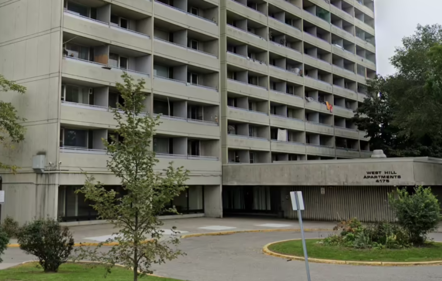 Photograph of 4175 Lawrence Avenue East building, showing circle driveway, 5 floors of apartments balcony, and greenery in front of the building. 