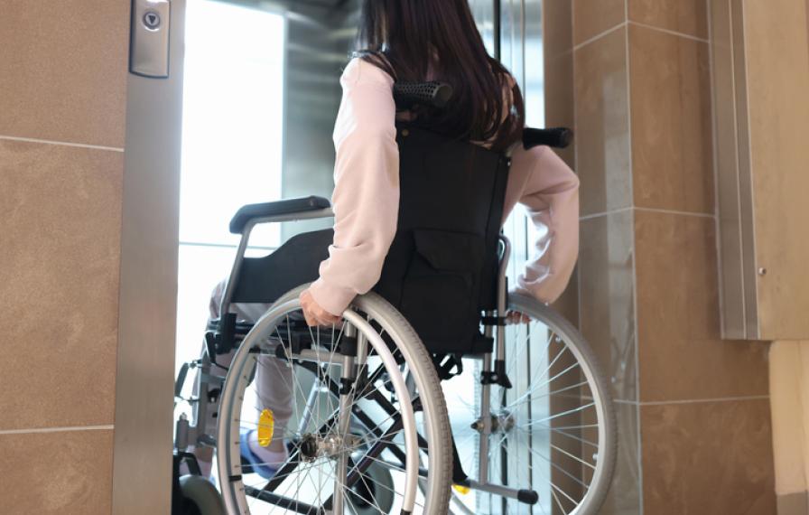 person in a wheelchair entering an elevator