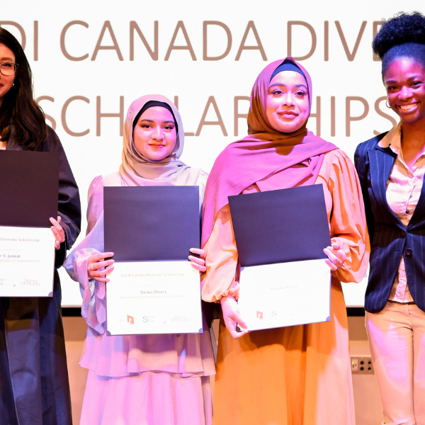 Four diverse females standing on stage holding their IIODS certificates. 