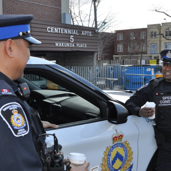 Two special constables talking in front of a vehicle.  