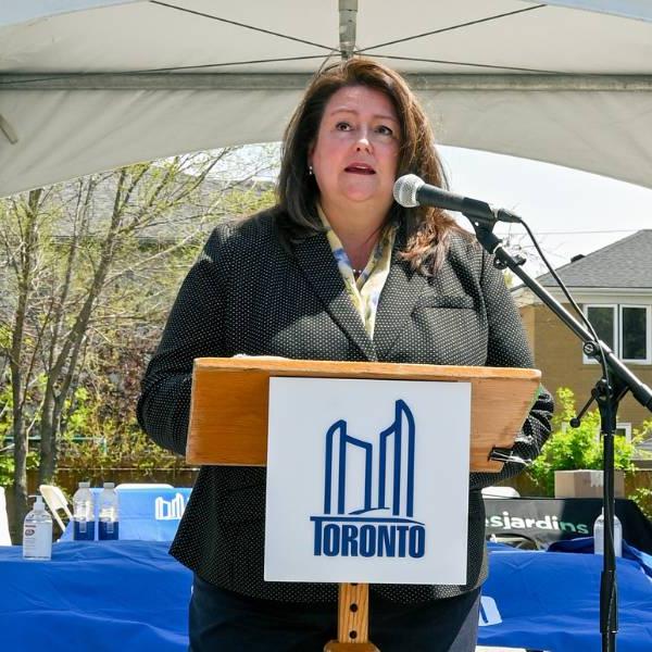 A woman stands at a City of Toronto podium making a speech