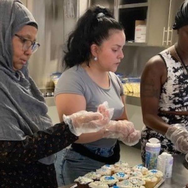 A group of women put the final touches on cupcakes for the Leslie Nymark Summer Jam in 2022