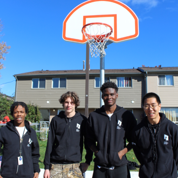 TCHC staff posing together on an outdoor basketball court