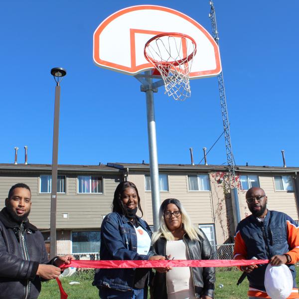 TCHC staff and tenants posing together on an outdoor basketball court