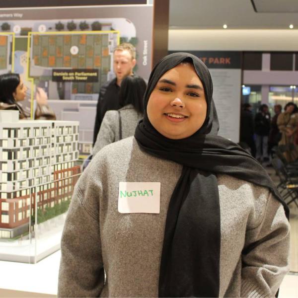 Nujhat Latif standing in a large foyer in front of a building display.