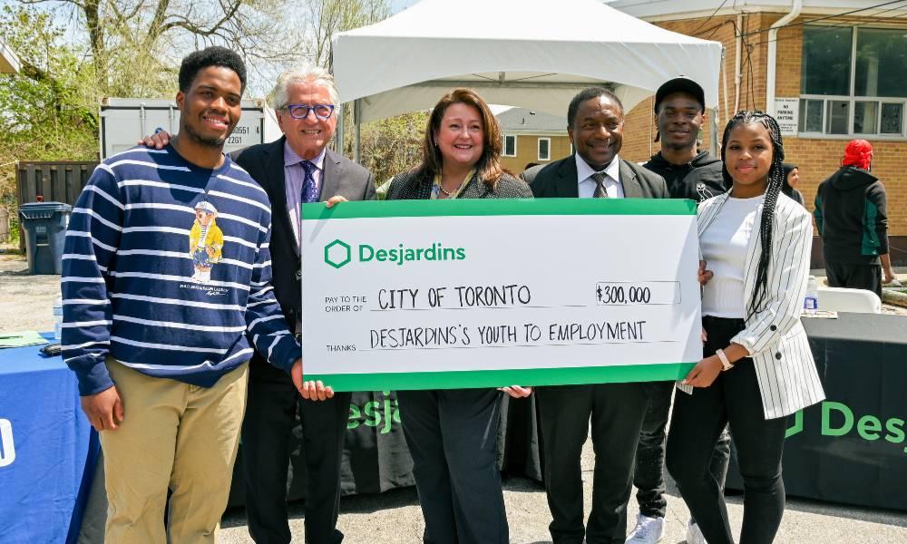 A group of people display a large check from Dejardin to the City of Toronto
