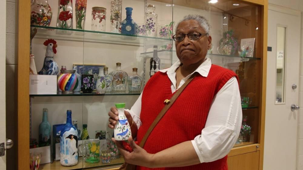 Fay Williams showcases her work of art of bluebirds painted on a soy sauce bottle.