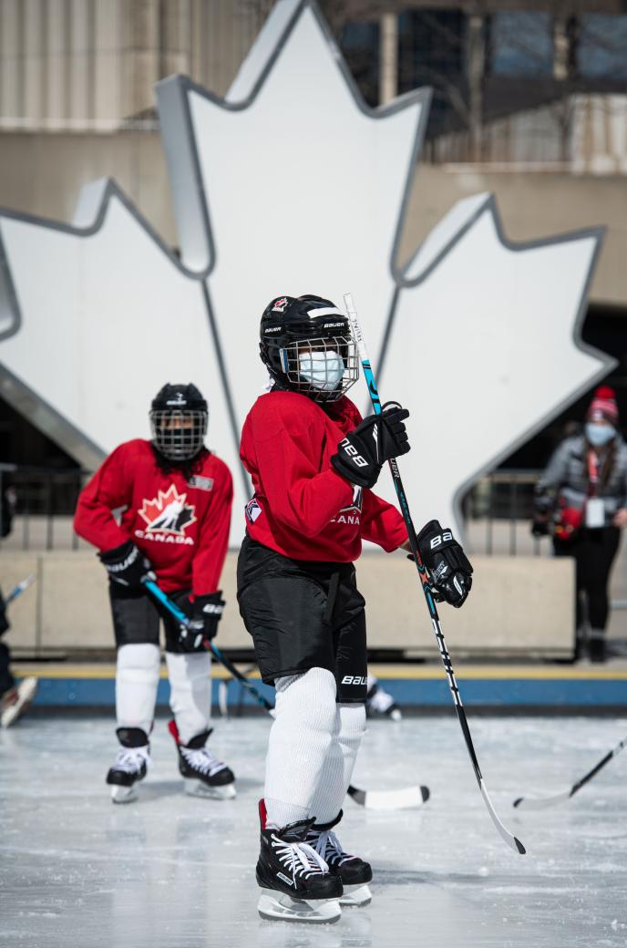 Tenant youth on an ice rink dressed in hockey equipment