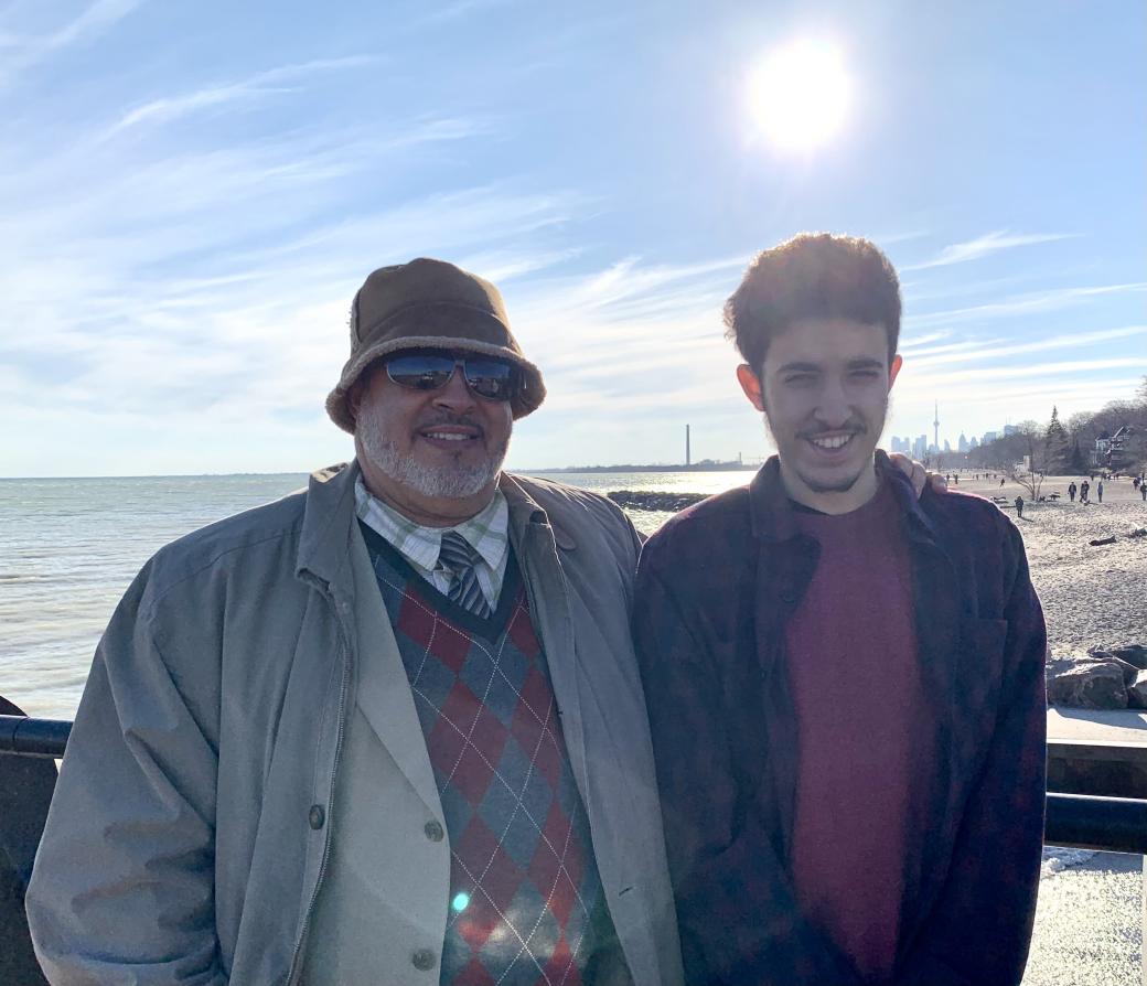 Photo of scholarship winner Ibrahim Rfifi and his father standing outside by Lake Ontario