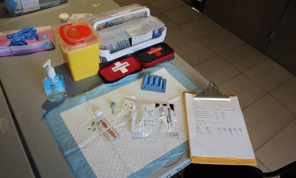 Medical supplies and a clipboard with paperwork laid out on a table.