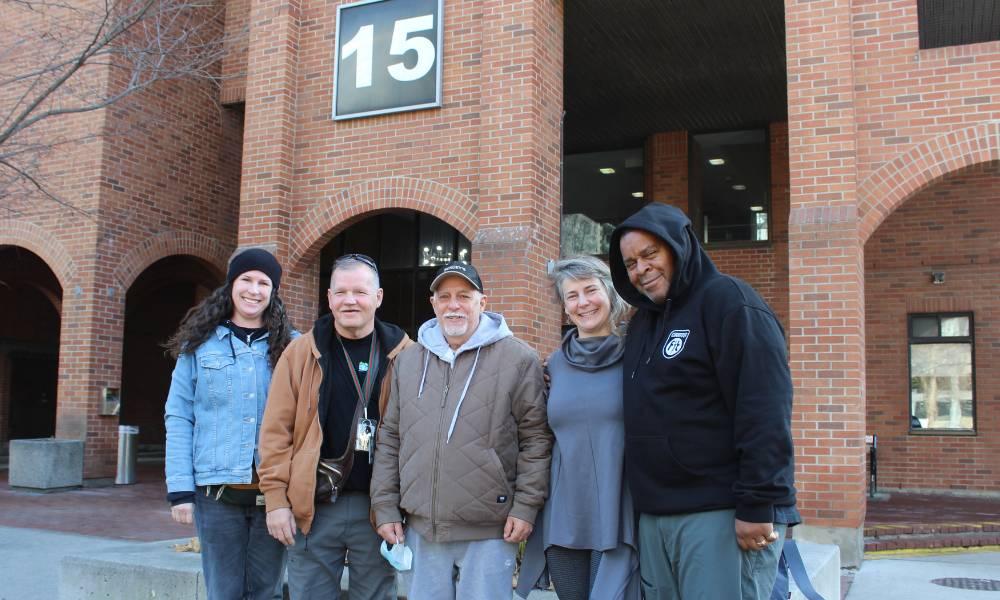 Five people standing outside in front of 15 Scadding Avenue building.