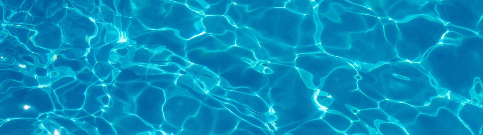Close up of water in a pool with reflections from the sunlight.
