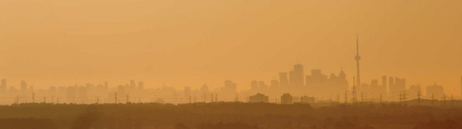 Hazy Toronto skyline, the horizon appears orange and the buildings in the distance are unclear due to smog
