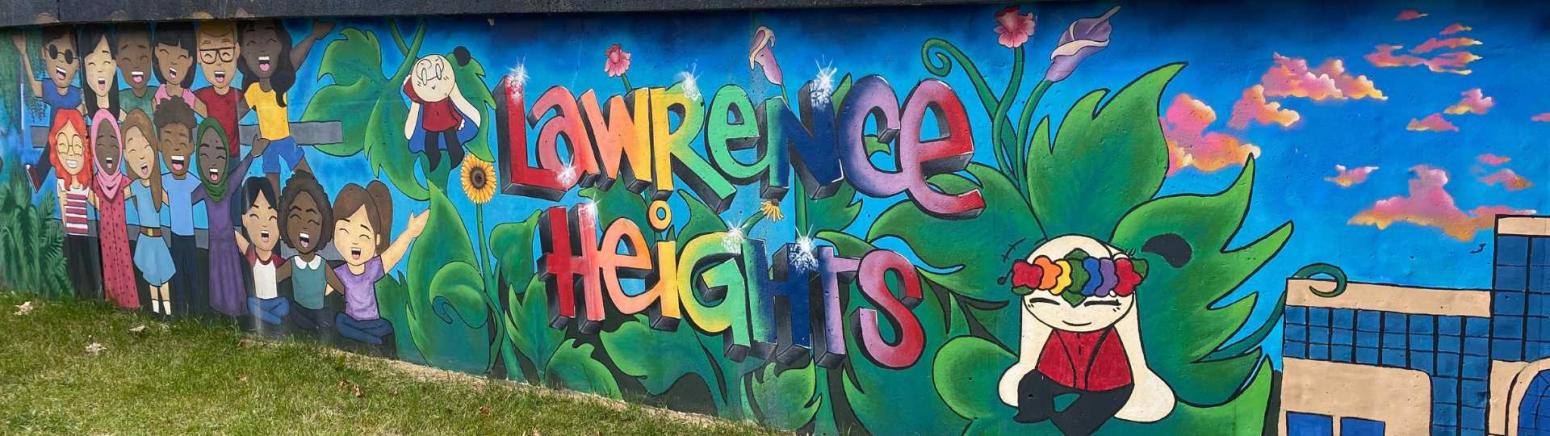Cartoon-style mural painted alongside a wall to celebrate Lawrence Heights. The left side of the mural shows a group of people who are standing side-by-side singing. On the right side, the edge of a building can be seen with pink and orange clouds overhead. In the centre, the words 'Lawrence Heights' painted in rainbow colours appears on top of leaves and plants with cartoon rabbits.